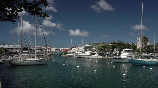 Boats moored in the Constitution River with the Chamberlain Bridge and Parliament Building in Bridgetown, Barbados.