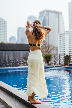 Beautiful woman walking on the edge of the pool