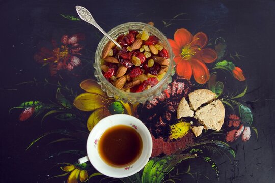Cup of coffee,cookie and raisins on the floral plate