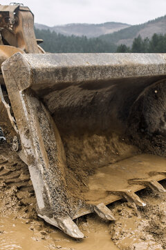 muddy bulldozer mould blade in the nature,forest in the background
