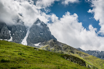 Majestical scene with mountains peaks in clouds in Georgia
