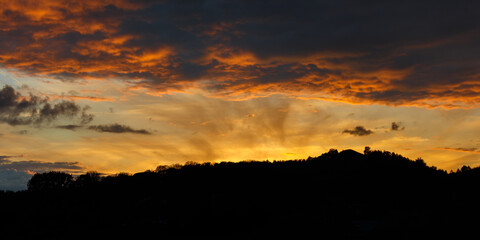 silhouette of hills at sunset or sunrise with cloudy sky