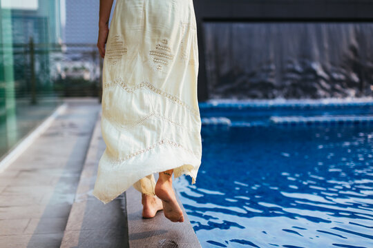 Beautiful woman walking on the edge of the pool