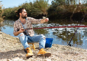 Adult male fisherman pulls fishing line on a fishing rod. High quality photo