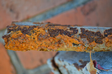 a piece of old square pipe overgrown with red rust