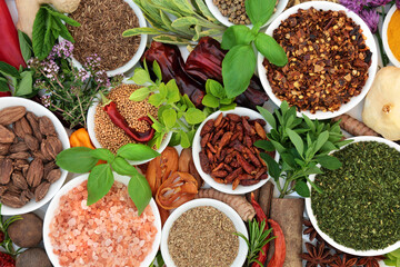 Dried and fresh culinary herbs and spice in porcelain bowls and loose. Flat lay.