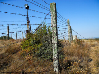 Pillars with barbed wire and spotlight       