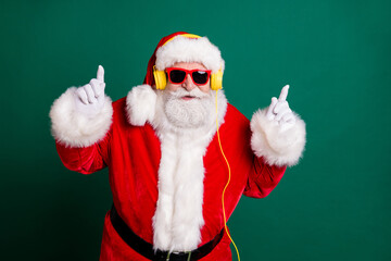 Portrait of his he nice attractive handsome cheery cool funny Santa father listening pop music bass single melody hit having fun rhythm party isolated over green color background