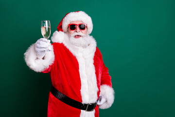 Portrait of his he nice attractive handsome cheerful cheery Santa father drinking champagne having fun congrats greetings toast festal day copy space isolated over green color background