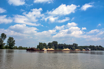 River boat pushes river barges