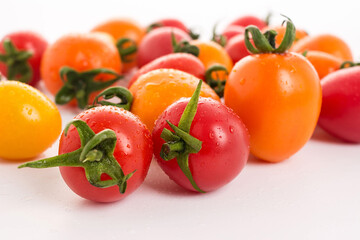 Multicolor small tomatoes on white background
