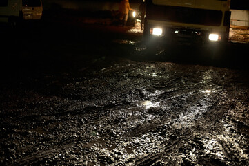 Construction site with mud and truck at night