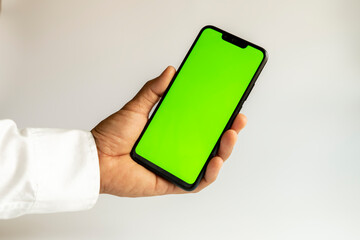 hand holding smartphone with green screen
