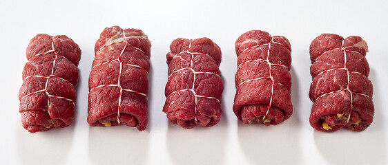 Line of raw beef roulades ready for cooking
