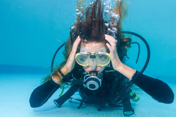 Woman scuba diving holding her head as if having ear equalization problem