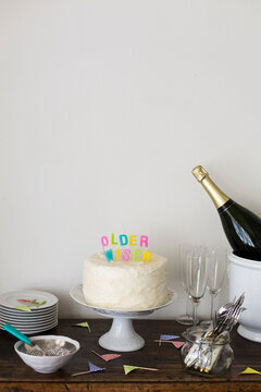 Cake corner at a party with cake and colourful birthday candles saying "Older, wiser"