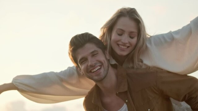 Close-up view of a joyful young couple man and woman have fun in the field