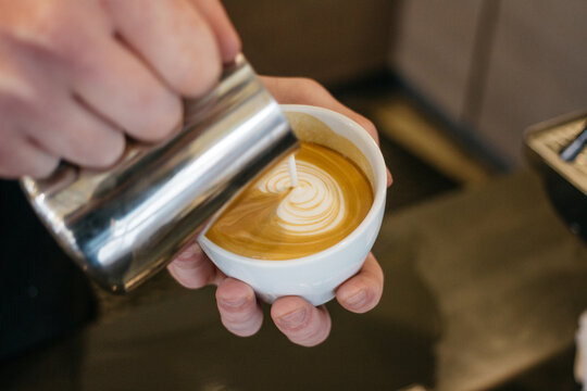 pouring latte cappuccino coffee, in cafe