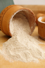 Sesame flour in a clay bowl on wooden background