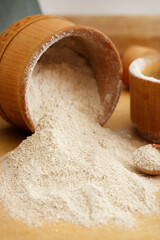 Healthy white sesame flour on wooden table