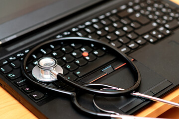 Obraz na płótnie Canvas close up of a stethoscope and a computer keyboard laptop