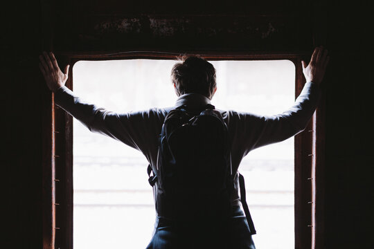 Man Looking Through an Abandoned Train Window