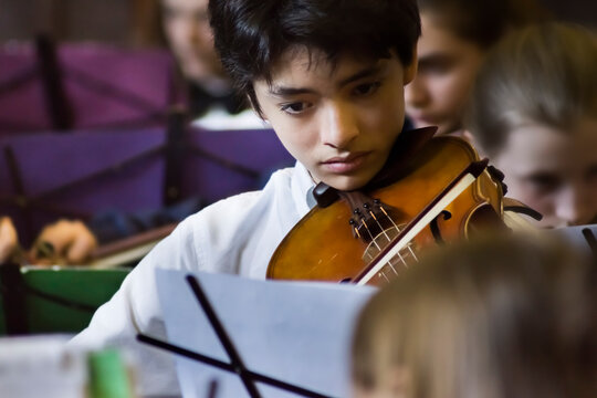 Asian teenage boy, playing the viola at a concert