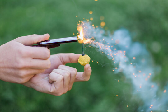 Shotgun lighter igniting a yellow smoke ball