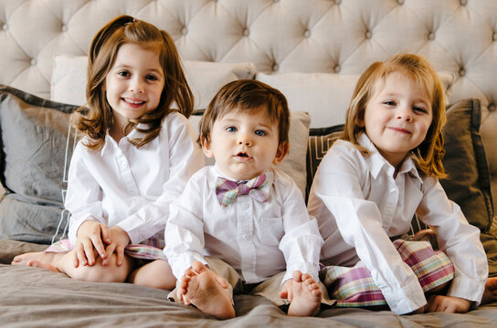 3 siblings in matching outfits, one smirking a bit