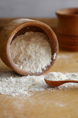 Coconut flour in wooden bowl isolated on brown. Top view.