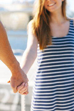 Closeup of young couple holding hands.