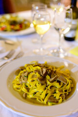 Tasty homemade tagliatelle pasta with fresh harvested boletus porcini mushrooms in creamy sauce
