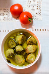 Italian food, pickled drilled artichokes hearts in olive oil
