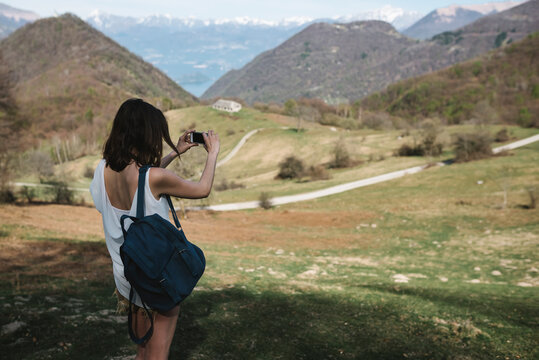 Young woman taking pictures in mountain