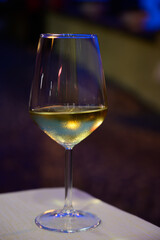 Glass of cold dry white wine served outdoor in cafe at night in Italy