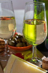 Glasses of dry fino sherry wine served with spanish tapas, manchego cheese, green olives, cheese crackers