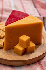 Matured yellow and red waxed cheddar cheese close up