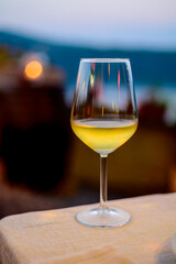 Glass of cold dry white wine served outdoor in cafe at night in Italy