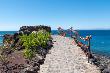 Fototapeta premium View of the promenade of Playa Flamingo in Playa Blanca, on the coast of the island of Lanzarote,
