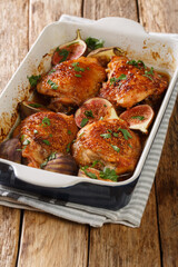 Mediterranean menu chicken thighs baked with ripe figs and herbs close-up in a baking dish on the table. vertical