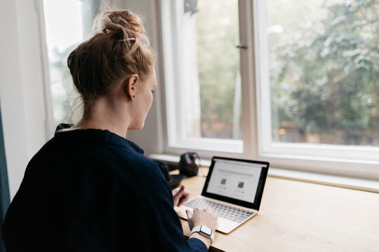 Woman sitting at desk on computer