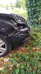 Crashed car with a destroyed front and car engine hood shows misfortune and the need for car insurance to avoid financial total loss and collision safety or repair after collision and emergency