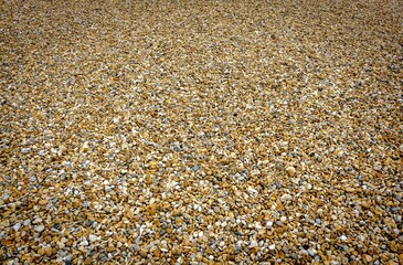 An empty pebble beach on the south coast of England. A random pattern of pebbles. No people. Plenty of copy space.