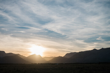 The sun sets into a mountain range