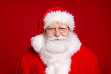 Photo of pensioner old man smiling wait elves help finish work prepare delivery christmas eve presents children wear santa costume spectacles headwear isolated red color background