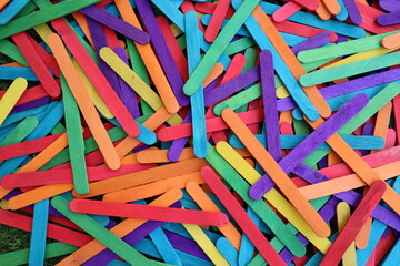 Multicolored popsicle sticks in bulk in shades of purple red light blue yellow orange green for desktop background b