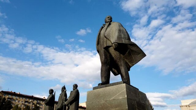 Vladimir Lenin statue in the city of Novosibrisk. Concepts of historical personalities. Time lapse shot with beautiful blue sky and white clouds