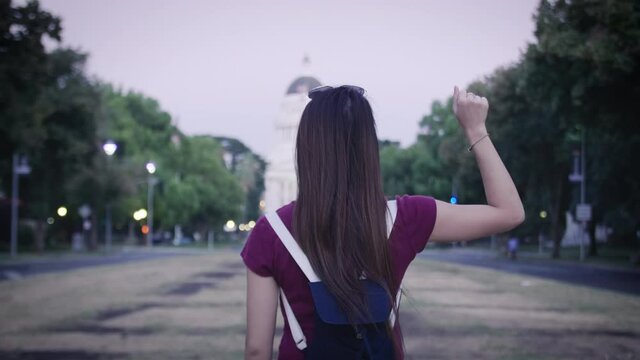 Woman raises fist symbol gesture in front of Capitol Building