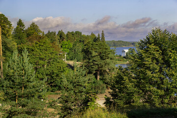Landscape with a steep granite coast and a bay of the Baltic sea. With a white gazebo in the...