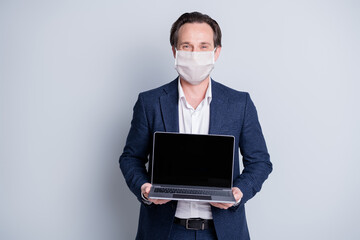 Portrait of serious fired clerk guy agent broker realtor wearing safety mask holding in hands...
